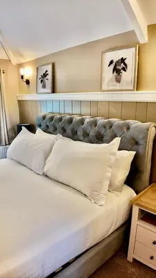 a bedroom with a large bed with white pillows at Rising Sun Inn - Bronn Ewhella in Altarnun