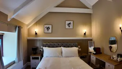 a bedroom with a bed and a desk and a window at Rising Sun Inn - Kil Margh in Altarnun