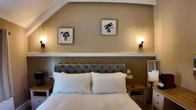 a bedroom with a bed and two lights on the wall at Rising Sun Inn - Kil Margh in Altarnun