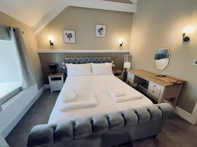 a bedroom with a large bed with two pillows on it at Rising Sun Inn - Kil Margh in Altarnun