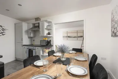 a kitchen and dining room with a wooden table and chairs at Sunset View - Sea View - Pet Friendly - Free WiFi - Free Parking in Marazion
