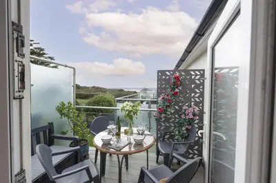 a balcony with a table and chairs and a view at Sunset View - Sea View - Pet Friendly - Free WiFi - Free Parking in Marazion