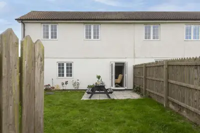 a white house with a wooden fence at Sunset View - Sea View - Pet Friendly - Free WiFi - Free Parking in Marazion