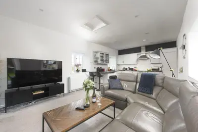a living room with a couch and a table at Sunset View - Sea View - Pet Friendly - Free WiFi - Free Parking in Marazion