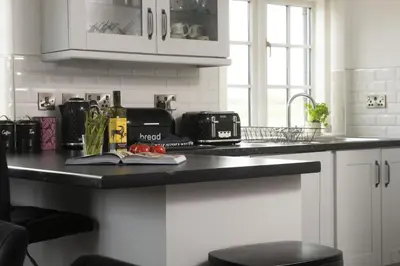 a kitchen with a black counter top with a sink at Sunset View - Sea View - Pet Friendly - Free WiFi - Free Parking in Marazion