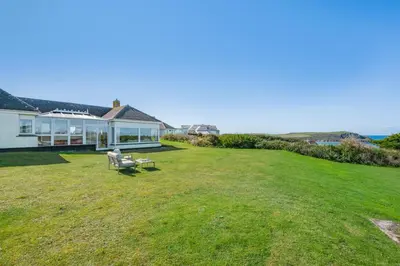 a large grassy yard with a white house at 5 Bed in Trebetherick oc-t33296 in Polzeath
