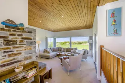 a living room with a couch and a stone wall at 5 Bed in Trebetherick oc-t33296 in Polzeath