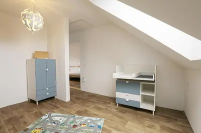 an attic room with a blue cabinet and a staircase at Penn Cottage perfect for North Cornwall trips in Camelford