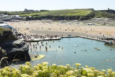 a group of people in a swimming pool at a beach at Penn Cottage perfect for North Cornwall trips in Camelford