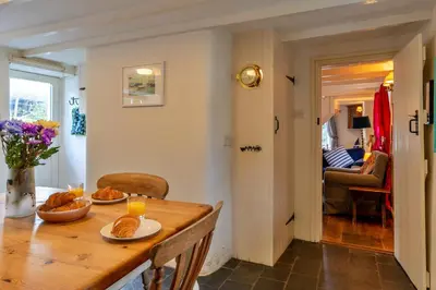 a dining room with a table with food on it at Finest Retreats - Forge Cottage, Padstow in Padstow
