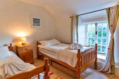 a bedroom with two beds and a window at Finest Retreats - Forge Cottage, Padstow in Padstow