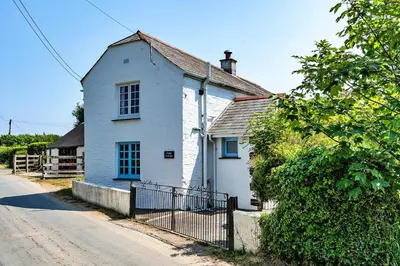 a white house on the side of a street at Finest Retreats - Forge Cottage, Padstow in Padstow