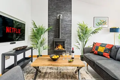 a living room with a couch and a fireplace at Kimberley Cottage - Stylish cottage & parking in Falmouth