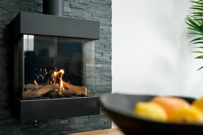 a fireplace in a living room with a fire in it at Kimberley Cottage - Stylish cottage & parking in Falmouth