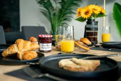 a table with two plates of food and orange juice at Kimberley Cottage - Stylish cottage & parking in Falmouth