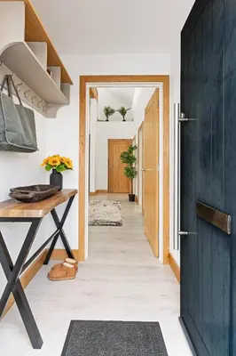 a hallway with a blue door and a table at Kimberley Cottage - Stylish cottage & parking in Falmouth