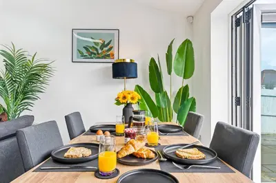 a dining room table with food and orange juice at Kimberley Cottage - Stylish cottage & parking in Falmouth