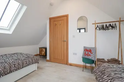 a bedroom with a bed and a wooden door at Barn 2 in St Austell