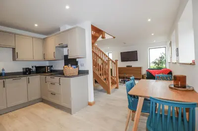 a kitchen and dining room with a table and chairs at Barn 2 in St Austell