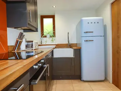a kitchen with a white refrigerator and a sink at 3 The Old Cornstore in St. Agnes
