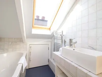 a bathroom with a large white tub and a skylight at 3 The Old Cornstore in St. Agnes