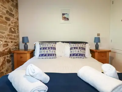 a bedroom with a bed with white towels on it at 3 The Old Cornstore in St. Agnes