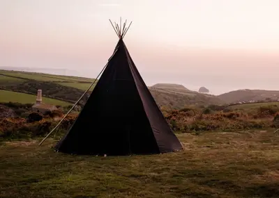 a black tent sitting on top of a field at Shanti Tipi 2 in Tintagel