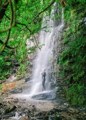 a man standing in front of a waterfall at Shanti Tipi 2 in Tintagel