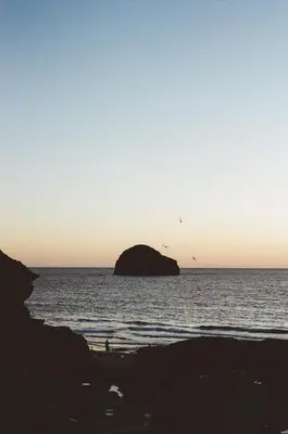 a person standing in the water at the beach at Shanti Tipi 2 in Tintagel