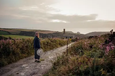 a woman standing on a dirt road with a frisbee at Shanti Tipi 2 in Tintagel
