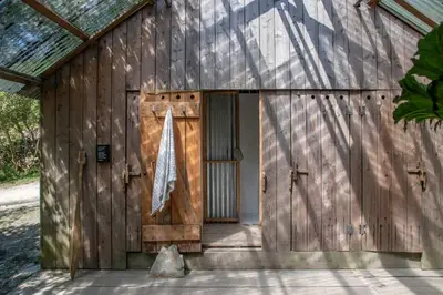 a wooden building with a door and a flag at Shanti Tipi 2 in Tintagel