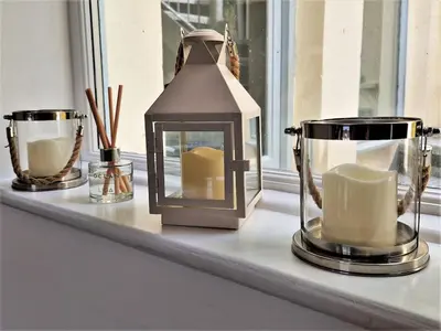a shelf with a lantern and two cups on it at The Bolthole in Fowey
