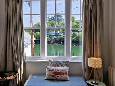 a window in a room with a pillow in front of it at The Bolthole in Fowey