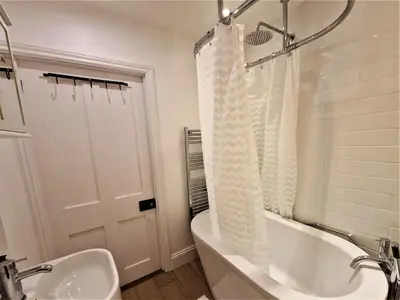 a bathroom with a tub and a sink and a shower at The Bolthole in Fowey