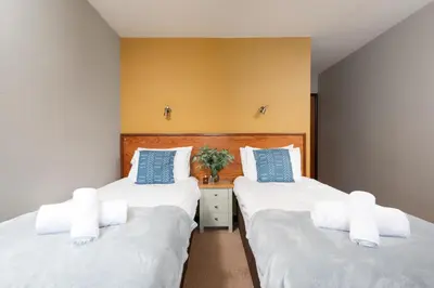 two beds sitting next to each other in a bedroom at Tricky's at The Tolgus Inn, Redruth - Free WiFi - Free Parking in Redruth