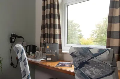 a desk with a window and a chair in a room at Tricky's at The Tolgus Inn, Redruth - Free WiFi - Free Parking in Redruth