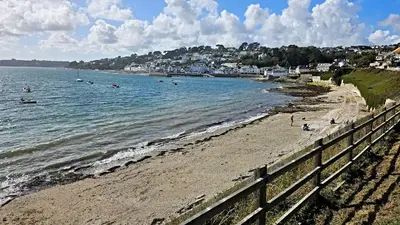 a beach with people swimming in the water at The Red House Annexe in Saint Mawes