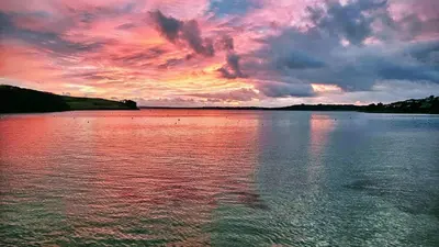 a sunset over a large body of water at The Red House Annexe in Saint Mawes