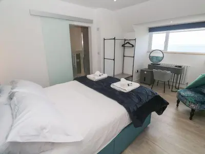 a bedroom with a bed with two towels on it at Shearwater in Penzance