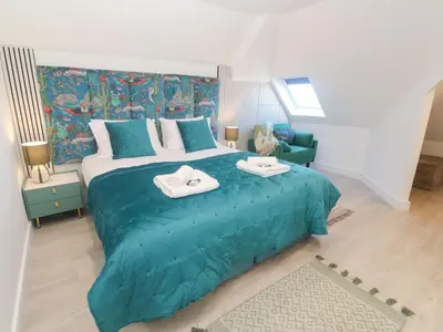 a bedroom with a large blue bed with towels on it at Shearwater in Penzance