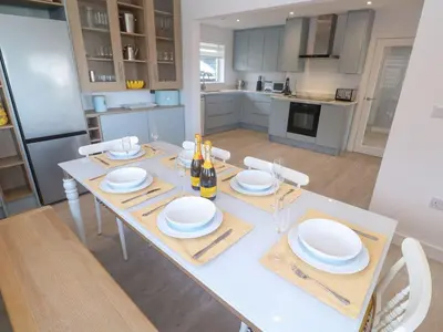 a kitchen with a table with plates and wine bottles at Shearwater in Penzance