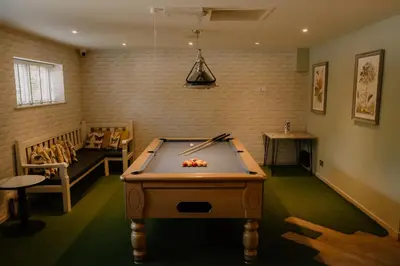 a room with a pool table in the middle of a room at Landal Clowance in Crowan