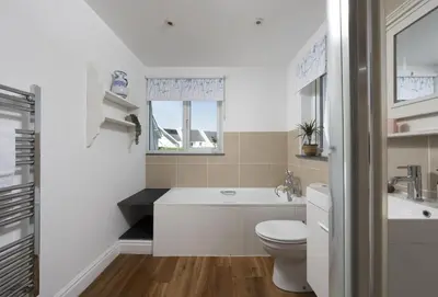 a bathroom with a toilet and a tub and a sink at Little Tresevens in Polzeath