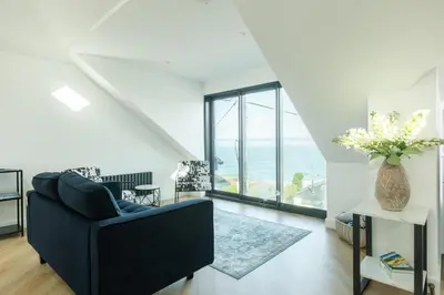 a living room with a black couch and a large window at 5 Bed in St. Ives oc-c28961 in Saint Ewe