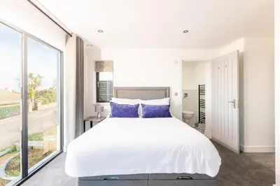 a bedroom with a large white bed with blue pillows at 5 Bed in St. Ives oc-c28961 in Saint Ewe