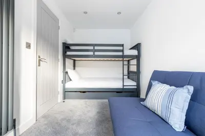 a bedroom with a blue couch and a bunk bed at 5 Bed in St. Ives oc-c28961 in Saint Ewe