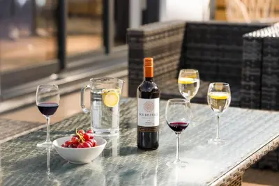 a bottle of wine and three wine glasses on a table at 5 Bed in St. Ives oc-c28961 in Saint Ewe