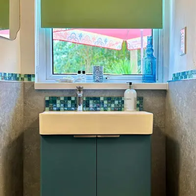 a sink in a bathroom with a window and a counter at Turtle retreat in Falmouth