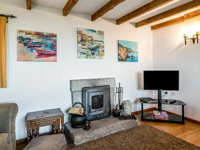 a living room with a fireplace and a tv at Wharrastone - Uk50661 in Bude