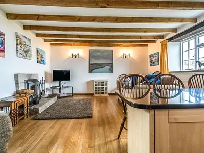 a living room with a bar with chairs and a table at Wharrastone - Uk50661 in Bude